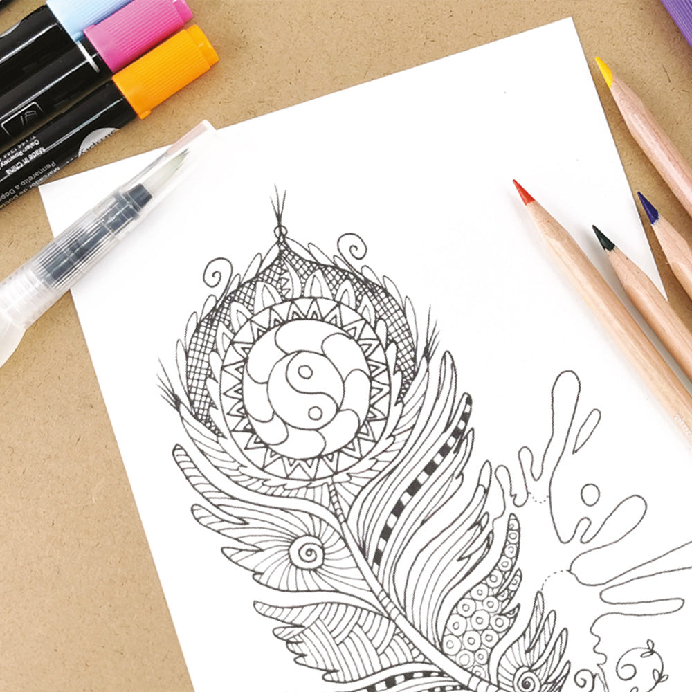 Coloring book page with intricate design and art supplies on a wooden surface