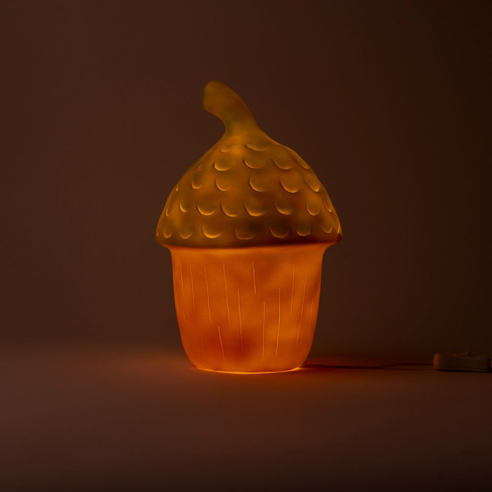 Glowing acorn-shaped lamp on a dark background