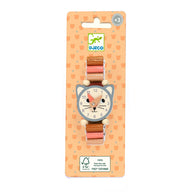 A DJECO wooden cat-shaped watch on a peach-colored backing card. The watch features a gray cat face with a white clock face, pink hands, and a brown and pink wooden link strap with white wooden beads.