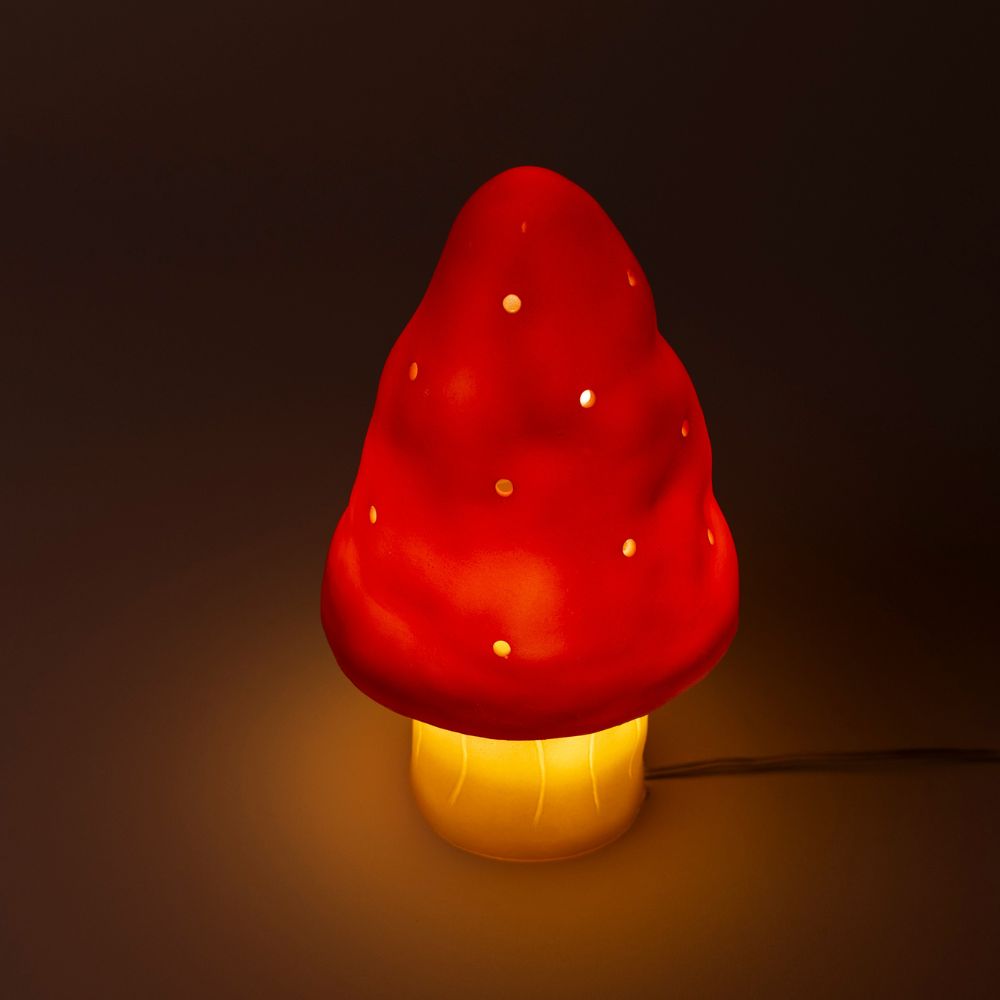 Mushroom-shaped lamp with red cap and yellow base on a dark background