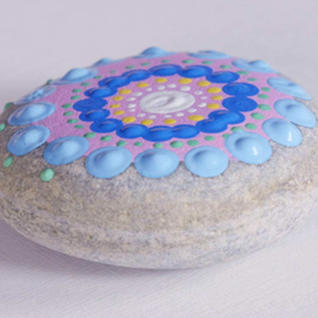 Decorative stone with a colourful mandala design on a white background